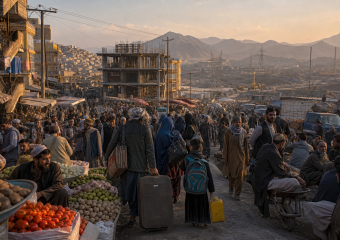 Crowded outdoor market with produce vendors, shoppers, unfinished buildings, and mountains in the background